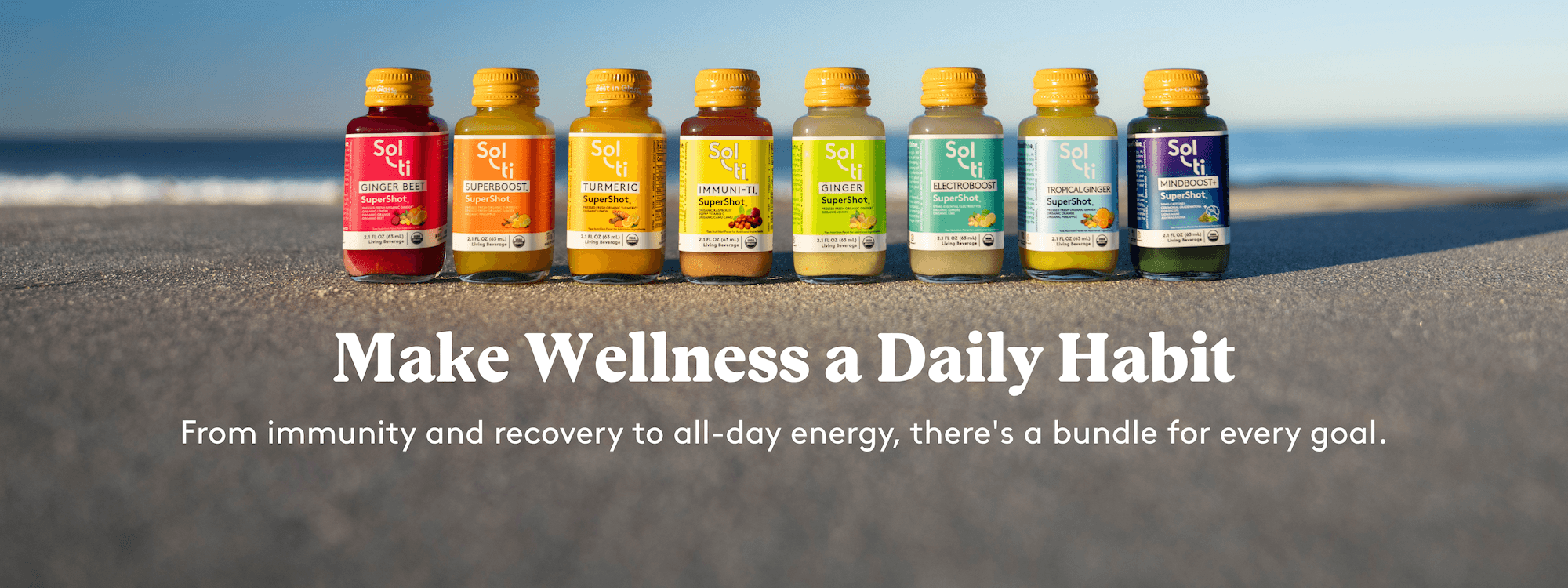 Eight SuperShot bottles lined up on a sandy beach. text 'Make Wellness a Daily Habit'