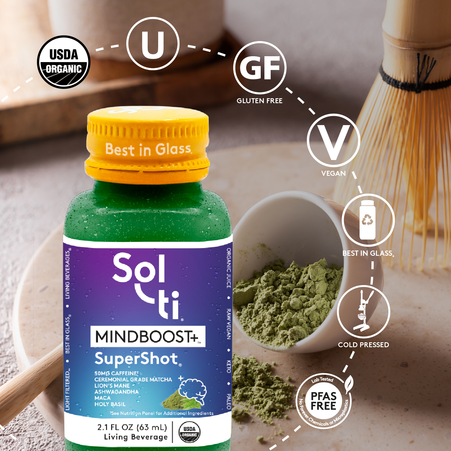 Sol-ti MINDBOOST+ SuperShot glass bottle with front label on ceremonial grade matcha background, showing matcha, with logo benefits: USDA Organic, kosher, Gluten Free, Vegan, Best in Glass, Cold pressed and Lab tested No forever Chemicals or microplastics