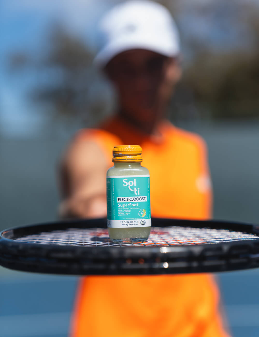 A ELECTROBOOST SuperShot placed on the throat of a tennis racket held by Andy Johnson