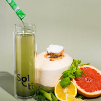 Thumbnail for A Sol-ti Glass Bottle with Chlorophyll Lemon SuperStix and water, next to Coconut, grape fruit, celery and lemon slices 