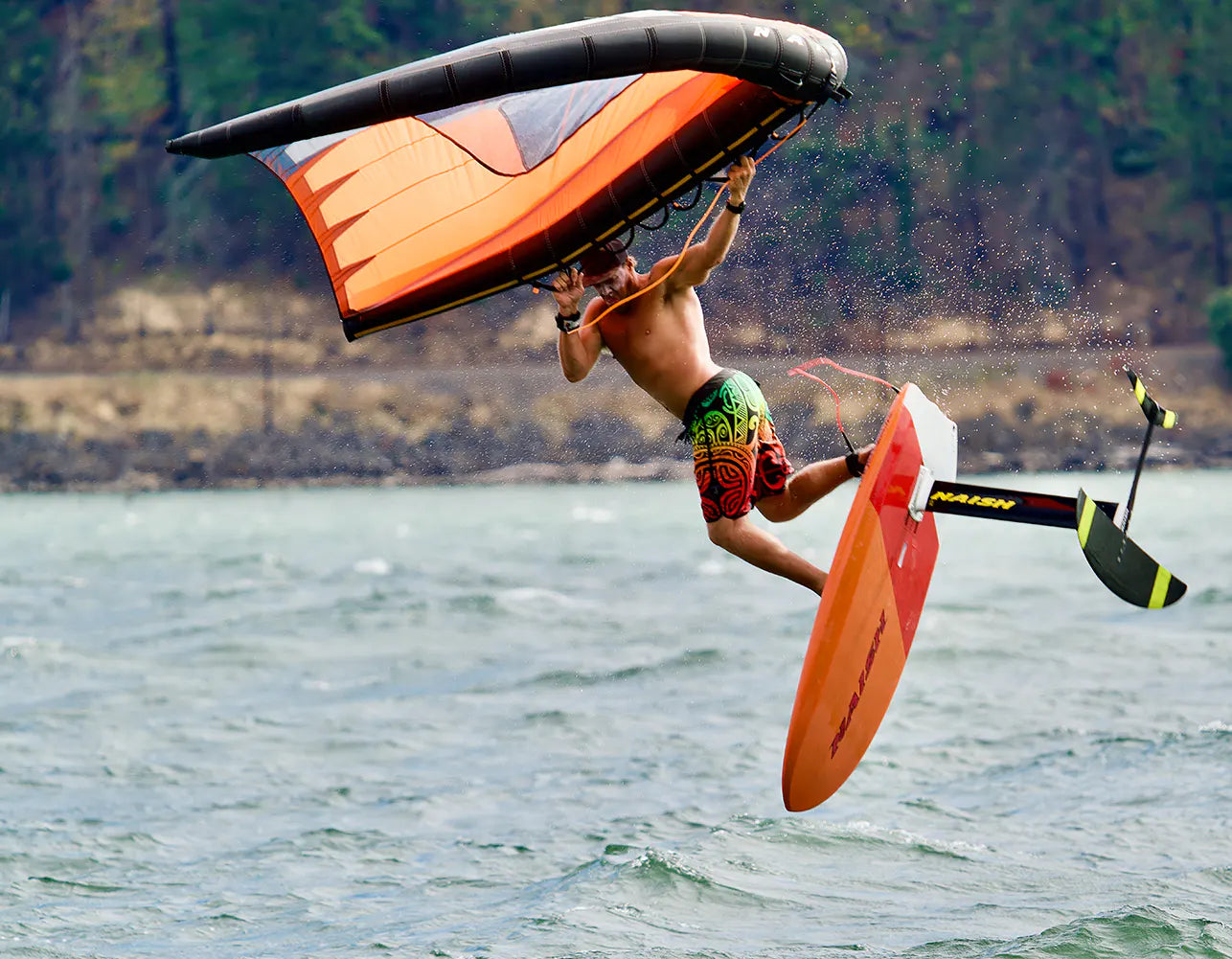 Chuck Patterson windsurfing mid-air during a jump over choppy water