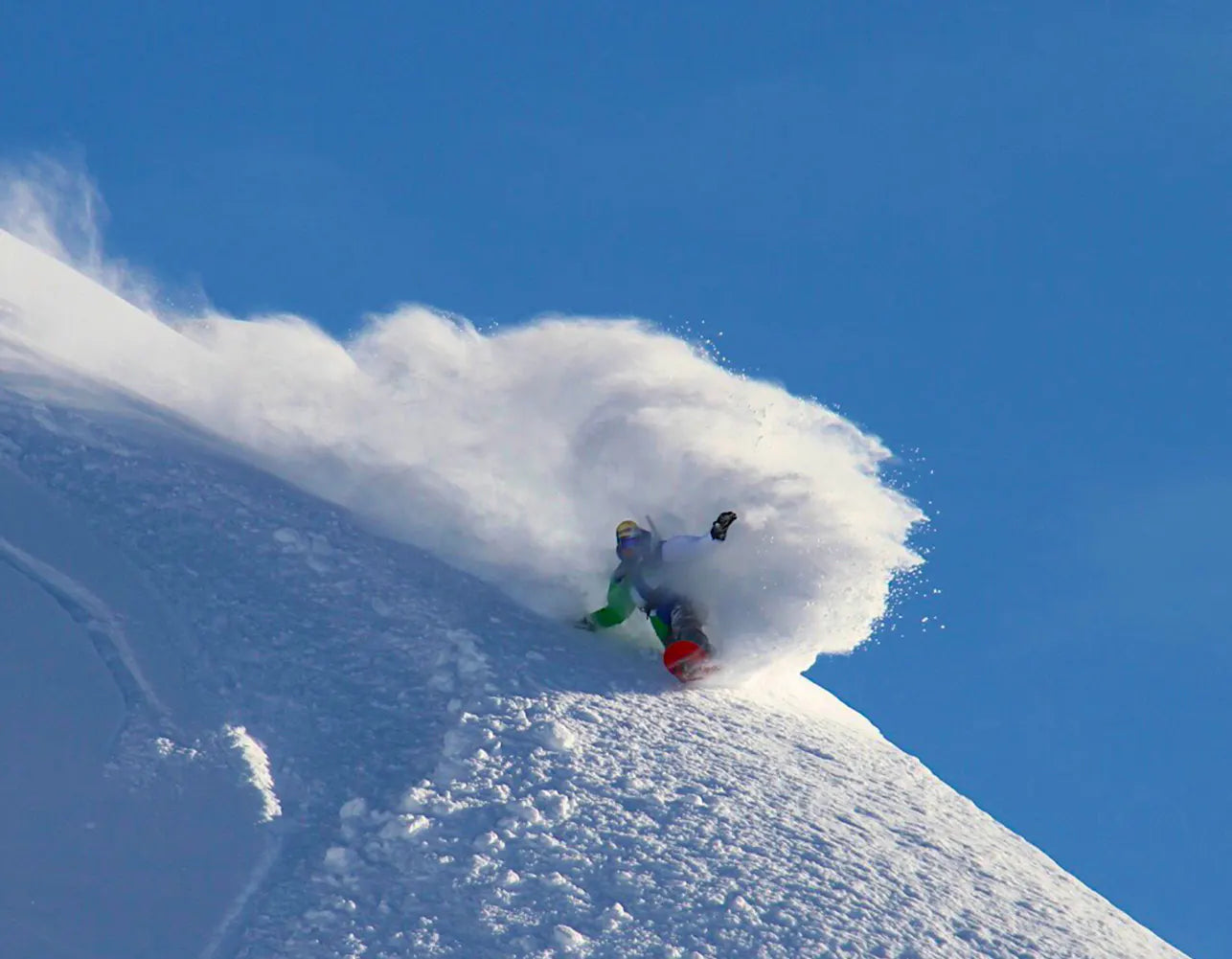 Chuck Patterson carving through fresh powder on a snowy mountain slope