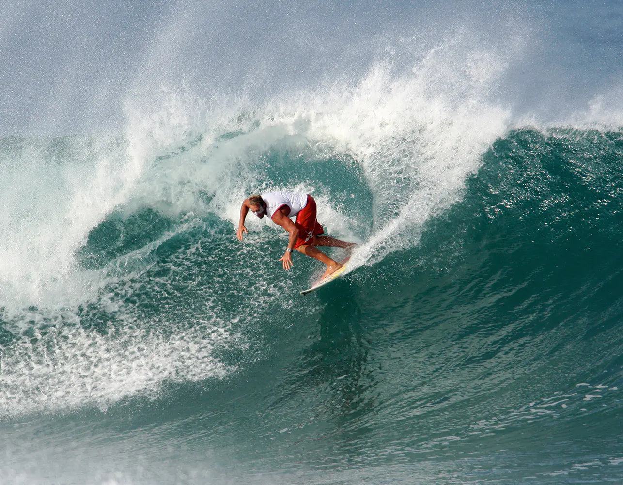 Chuck Patterson rides a curling ocean wave, captured mid-action 