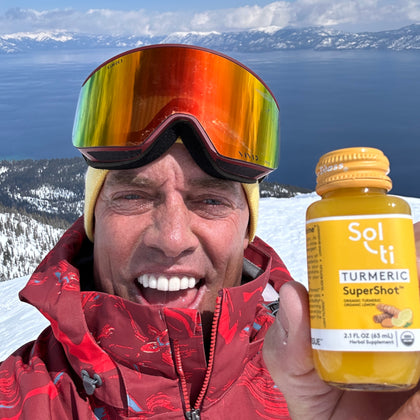 Chuck Patterson smiling holds a bottle of Sol-ti TURMERIC SuperShot in his hand