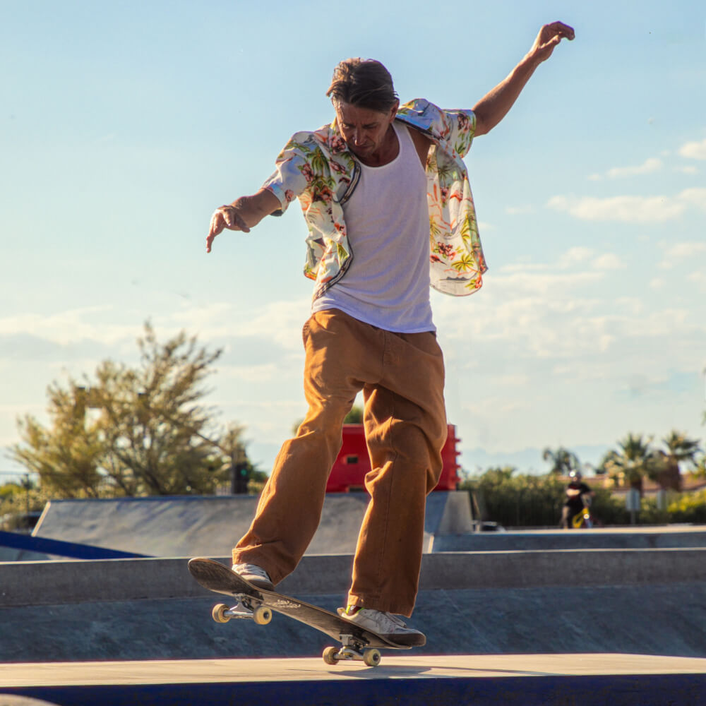 Joey Brenzinski skateboarding in a concrete park at sunset