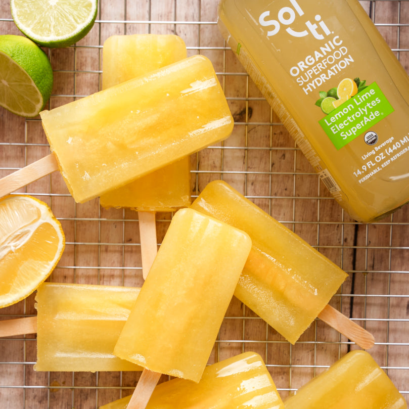 Yellow popsicles on a wire rack with Sol-ti Lemon Lime SuperAde glass bottle in the background