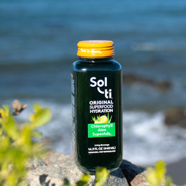 A bottle of Sol-ti Chlorophyll Aloe SuperAde, standing on a rock