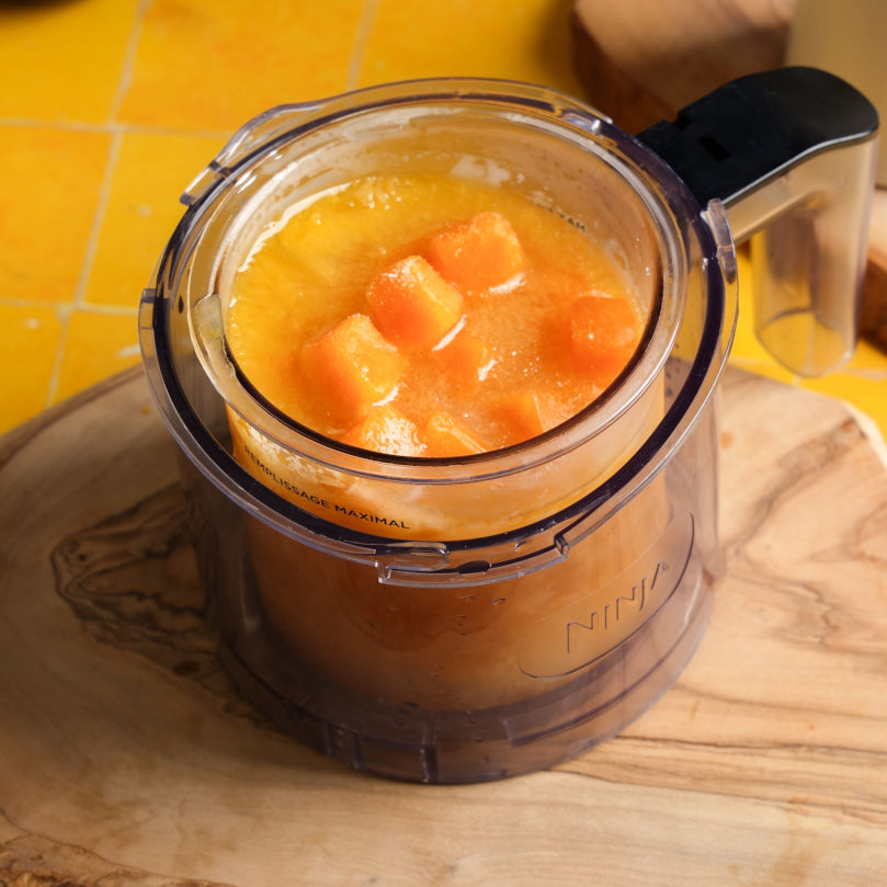 Blender container with a sorbet on a wooden surface