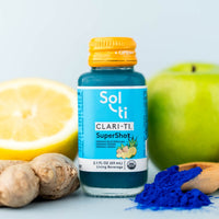 Thumbnail for A bottle of CLARI-TI SuperShot next to blue spirulina, green apple, ginger root, and lemon slices