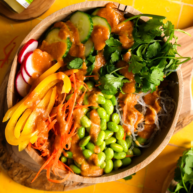 Spring Roll Bowl with various vegetables and kelp noodles on a yellow background