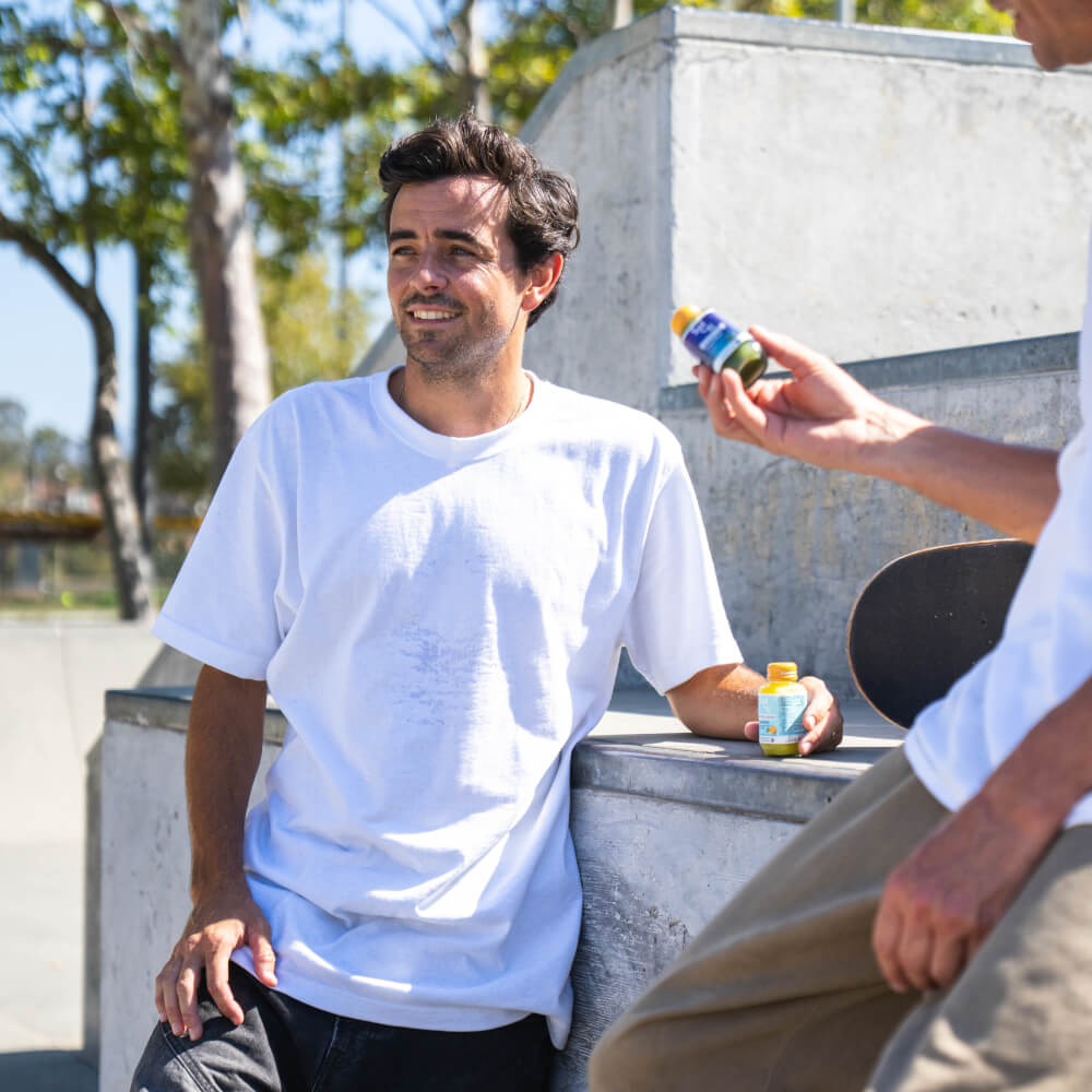 Trevor McClung sits at an outdoor concrete skatepark while a TROPICAL GINGER SuperShot