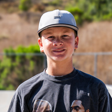 Wyatt Hammond wearing a light gray baseball cap and a dark gray t-shirt, photographed outdoors
